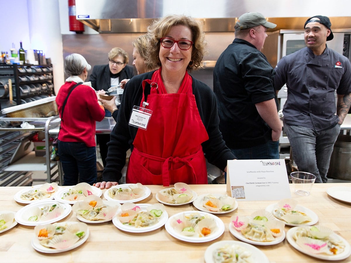 Beth Lee standing in front of her table of Jew Mandu at the Jew Asian food event.